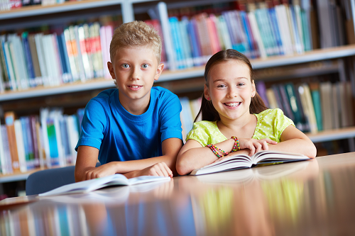 Boy and girl students sitting in table. 